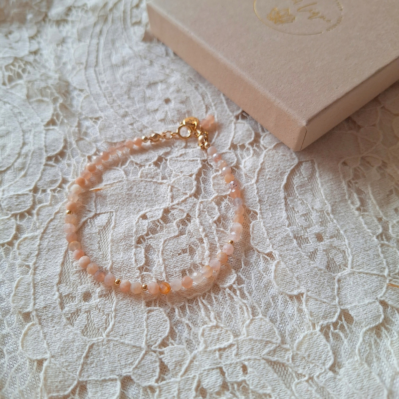 Perzik maansteen armband op kant met cadeaudoosje op de achtergrond