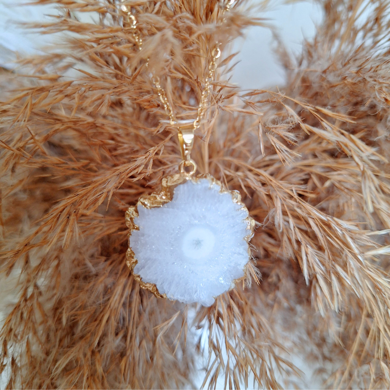Detail van agaat ketting met bruine tak als achtergrond