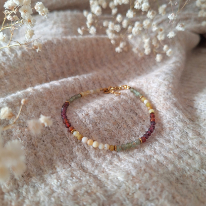 Apatiet armband met granaat en opaal op trui met droogbloemen