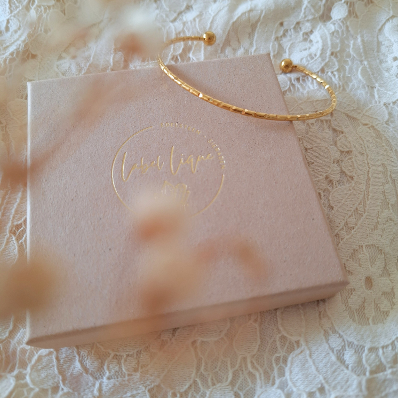 Gouden bangle met fijn werkje op een sieradendoosje