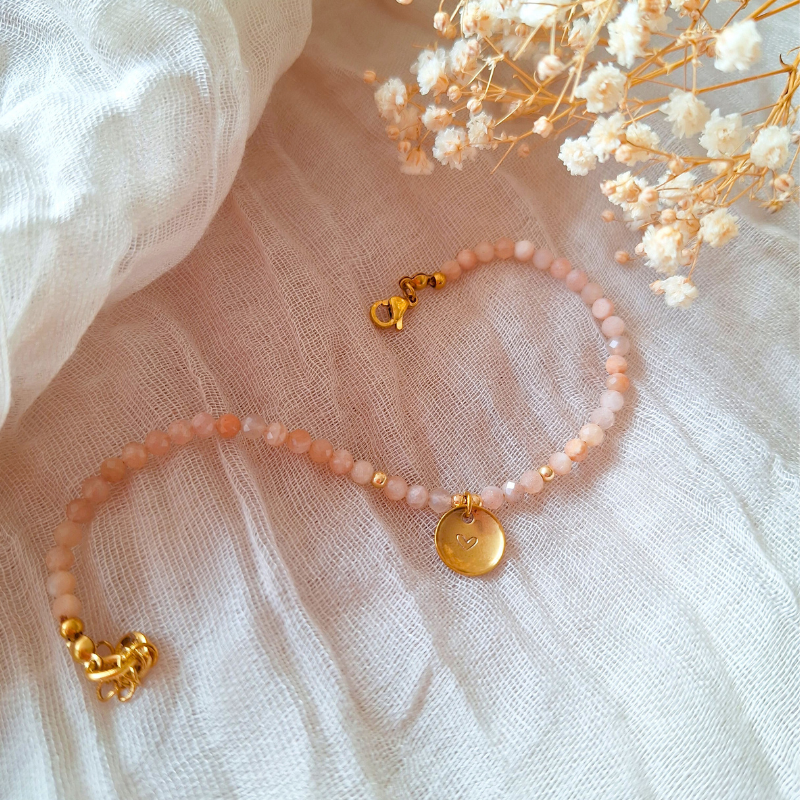 Maansteen armband met letter op zachte achtergrond