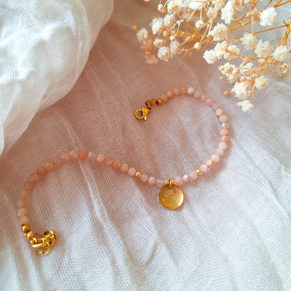 Maansteen armband met letter op zachte achtergrond