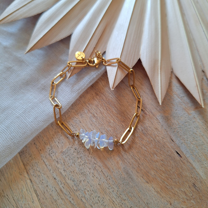 Opaline armband goud op houten ondergrond en lichte doek