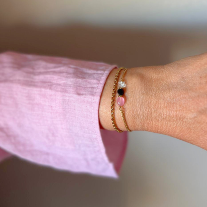 Rozenkwarts opaline armband handgemaakt in zacht natuurlijk licht op linnen stof