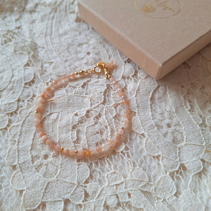 Perzik maansteen armband op kant met cadeaudoosje op de achtergrond